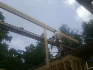 Carpenter setting a ridge beam over a new addition frame — Ice Dam Removal by Roofing Brothers in Pitsburg