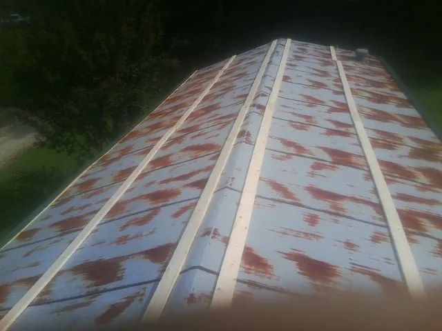 Rusted metal roof panels with new wood purlins before replacement — Storm Damage Roof Repair in Pitsburg by Roofing Brothers