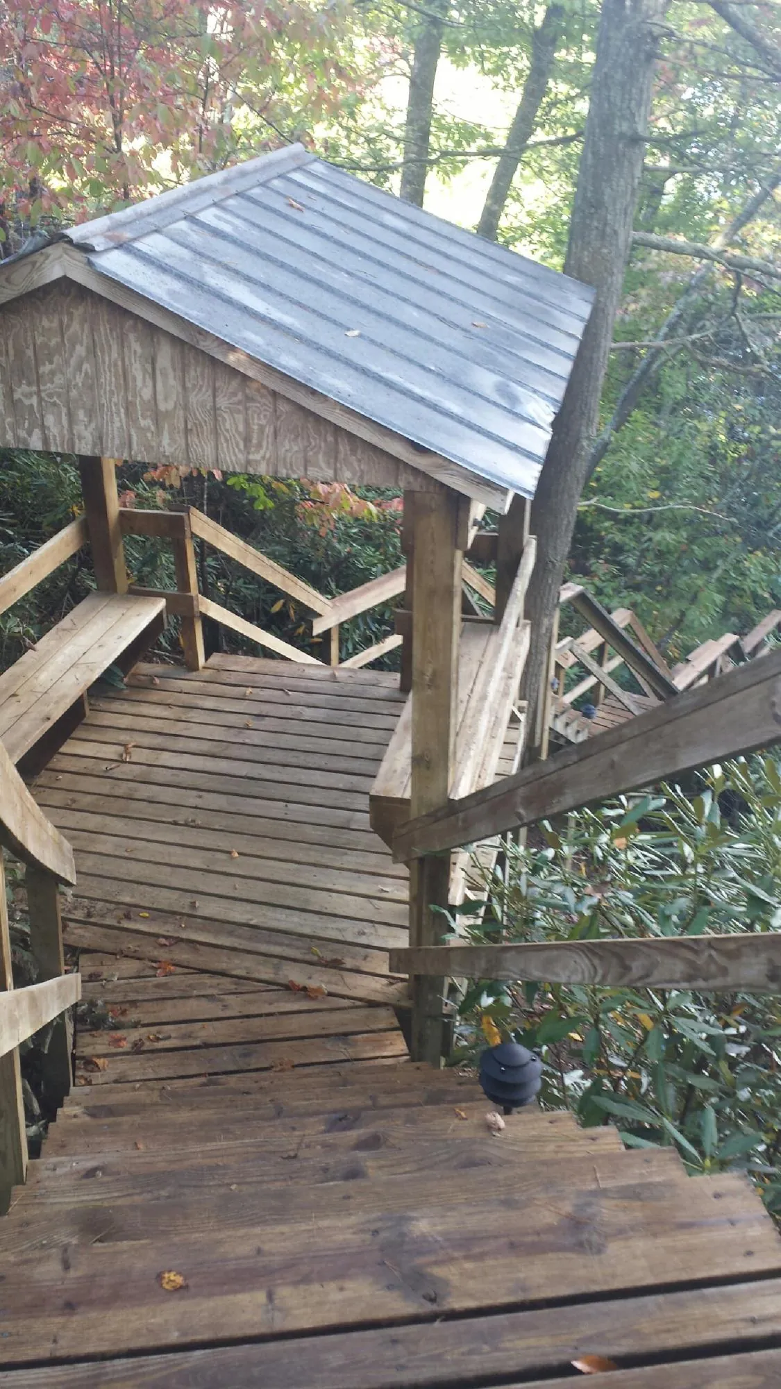 Metal roofed shelter over wooden steps on a wooded walkway — Skylight Repair & Installation work by our crew in Pitsburg