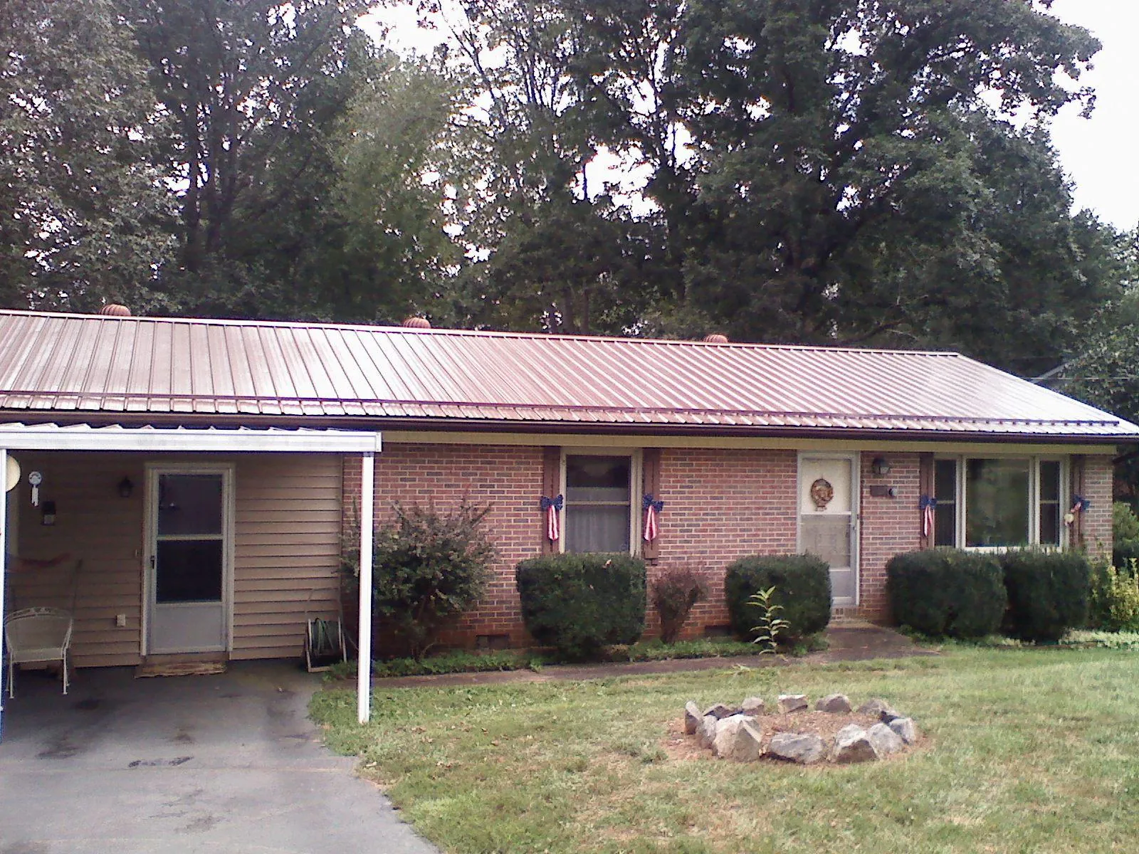 Bronze metal roof and carport on a brick ranch home — Roof Repair work by our crew in Pitsburg